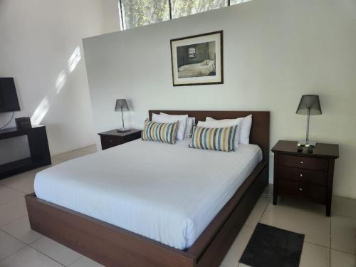 a bedroom with a large bed and two night stands at Le Bamboo Guest House And Boat Cruise in Hartbeespoort