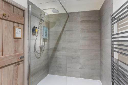 a shower with a glass door in a bathroom at The Barn at Plas Ashpool Sleeps 8 in Llandyrnog
