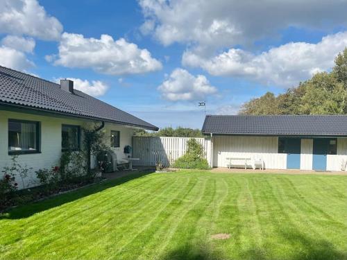 a house with a yard with green grass at Country house with sea view near Hovs Hallar in Båstad