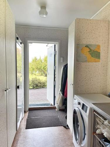 a kitchen with a door open to a laundry room at Country house with sea view near Hovs Hallar in Båstad