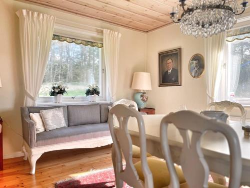 ein Wohnzimmer mit einem Sofa, einem Tisch und Stühlen in der Unterkunft Country house with sea view near Hovs Hallar in Båstad