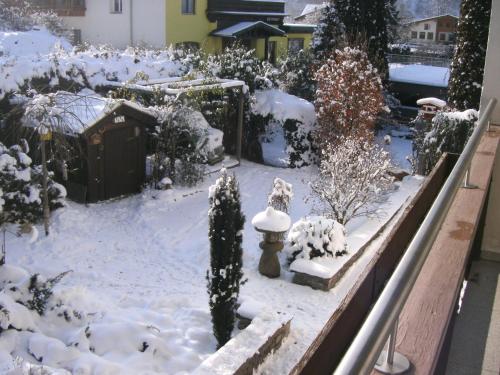 a garden covered in snow with a fire hydrant at Pension Garni Gerhard in Oetz