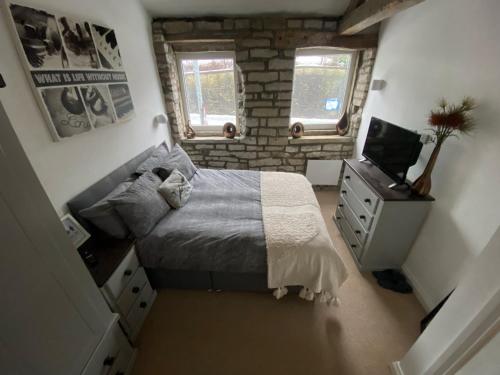 a small bedroom with a bed and a television at Robins mill in Rishworth