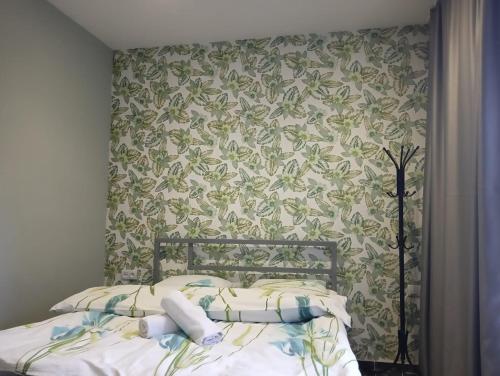 um quarto com uma cama com papel de parede floral em Gray Hotel em Lebedinovka