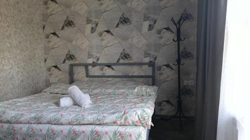 um quarto com uma cama e uma parede em azulejo em Gray Hotel em Lebedinovka
