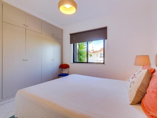 a bedroom with a large white bed with a window at AL - Sol Nascente ll Apartamentos in Vilamoura