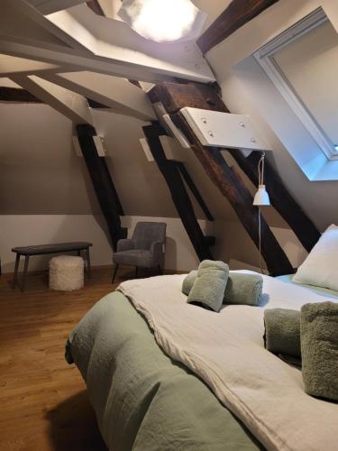 a bedroom with a large bed in the attic at Tresors de Sens in Sens