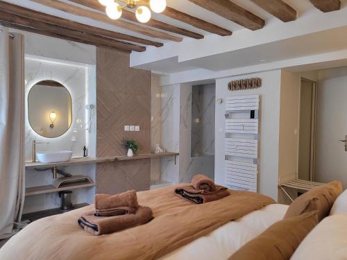 a bedroom with a large bed with towels on it at Tresors de Sens in Sens