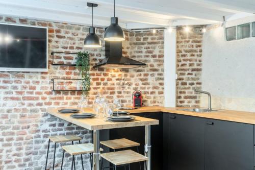 uma cozinha com uma mesa e uma parede de tijolos em Atypical flat in the centre of Lille. em Lille
