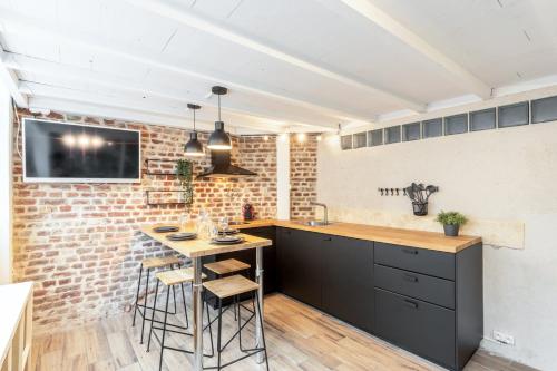 uma cozinha com uma mesa e uma parede de tijolos em Atypical flat in the centre of Lille. em Lille