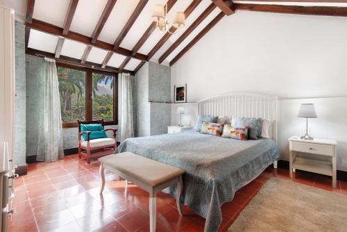 een slaapkamer met een bed en een stoel bij Finca Madroñal in Santa Brígida