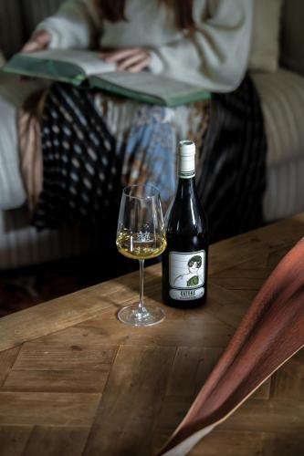 a bottle of wine and a glass on a table at Sella&Mosca Casa Villamarina in Alghero