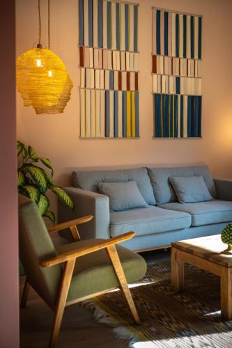 a living room with a blue couch and a table at Sella&Mosca Casa Villamarina in Alghero