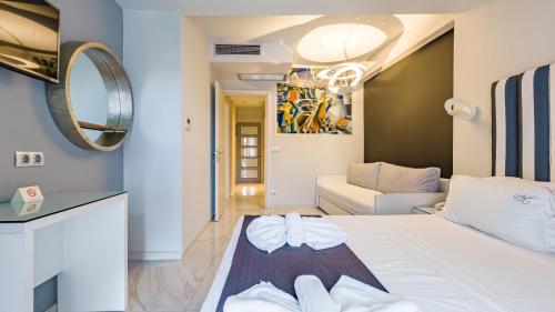 a bedroom with a white bed and a living room at Art Luxury Suites in Pefkohori