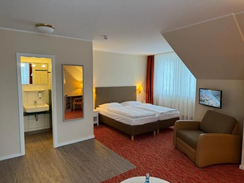 ein Schlafzimmer mit einem Bett, einem Sofa und einem Spiegel in der Unterkunft Mueßer Hof in Schwerin