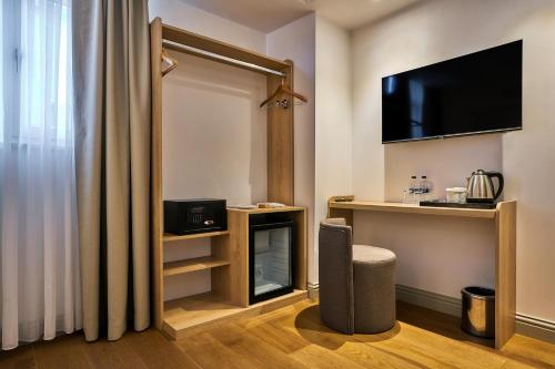 a hotel room with a tv and a chair at Joyway Hotels Istanbul Sultanahmet in Istanbul