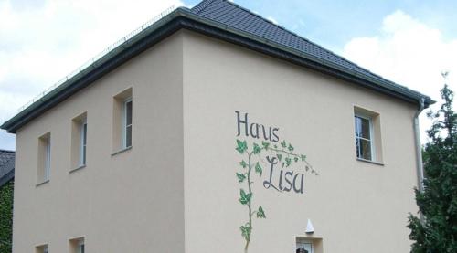 Ferienwohnungen _ Haus Lisa_ في سنفتنبرغ: مبنى ابيض وعليه لوحه جانبيه