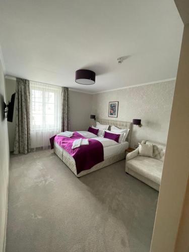 a bedroom with a large bed and a couch at Hotel Radetzky in Sankt Gilgen