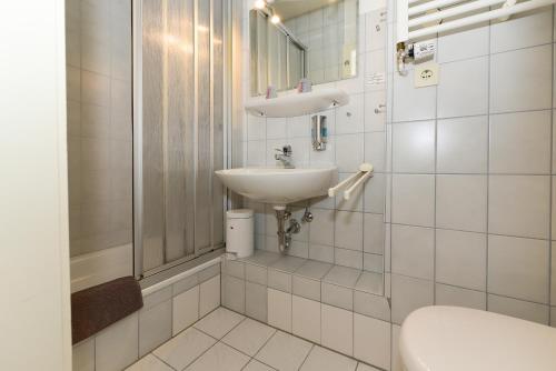 Baño blanco con lavabo y aseo en Pension Hilligenlei Zi 04 DZ, en Wyk auf Föhr