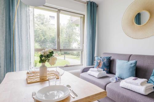 ein Wohnzimmer mit einem Sofa und einem Fenster in der Unterkunft Lovely Studio Neuilly sur Seine 2pers in Neuilly-sur-Seine