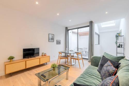 una sala de estar con un sofá y una mesa en Fully equipped duplex with exterior and parking !, en Lille