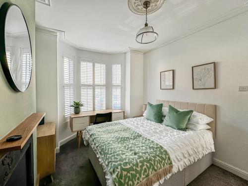 a bedroom with a bed and a desk and a mirror at Stylish Southsea Retreat in Portsmouth