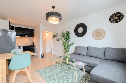 een woonkamer met een bank en een tafel bij Lille, fully-equipped apartment with parking space in Lille