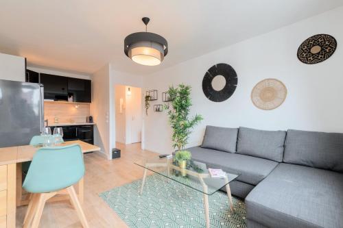 un salon avec un canapé et une table dans l'établissement Lille, fully-equipped apartment with parking space, à Lille