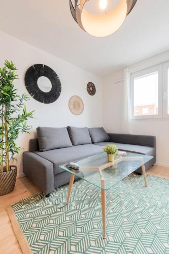 un salon avec un canapé et une table en verre dans l'établissement Lille, fully-equipped apartment with parking space, à Lille