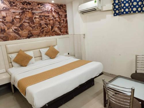 Aditya Inn Near New Delhi Railway Station Paharganj في نيودلهي: غرفة نوم بسرير مع لوحة على الحائط