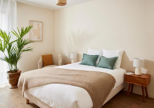 sypialnia z dużym białym łóżkiem z 2 poduszkami w obiekcie Casa Barbara Nice - Résidence Services w Nicei