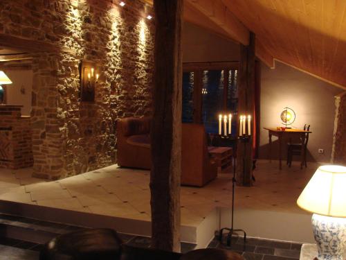 a living room with a stone wall at La Cense De Renière in Ferrières