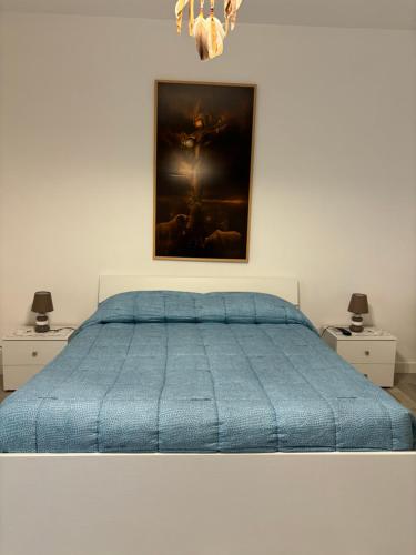a bedroom with a blue bed with two night stands at Vincent’s House in Mazara del Vallo