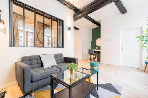 a living room with a couch and a table at Character apartment in the heart of Old Lille in Lille