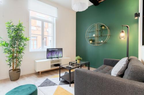 a living room with a couch and a tv at Character apartment in the heart of Old Lille in Lille
