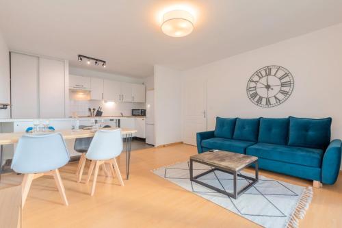 een woonkamer met een blauwe bank en een tafel bij Spacious apartment with parking and balcony! in Lille