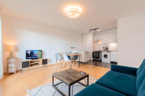 een woonkamer met een bank en een tafel bij Spacious apartment with parking and balcony! in Lille
