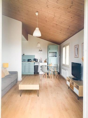 een woonkamer met een bank en een tafel bij la maison du vignoble in La Limouzinière