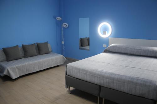 a blue room with two beds and a couch at Lasso B&B in Corigliano Calabro
