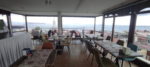 un restaurante con mesas, sillas y ventanas en BİG ORANGE HOTEL en Estambul
