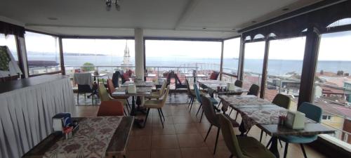 a restaurant with tables and chairs and windows at BİG ORANGE HOTEL in Istanbul