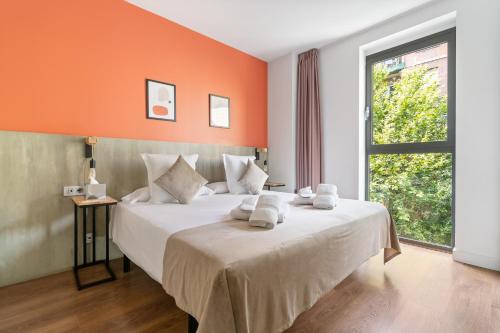 1 dormitorio con 1 cama grande y pared de color naranja en Sensation Sagrada Familia, en Barcelona