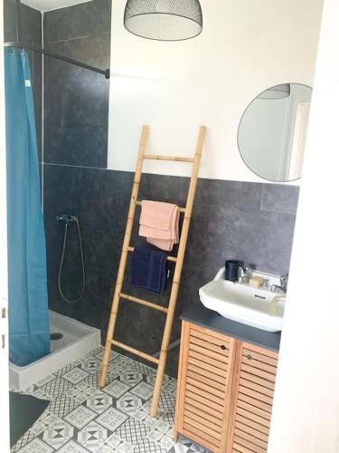 La salle de bains est pourvue d'une échelle et d'un lavabo. dans l'établissement la maison du vignoble, à La Limouzinière