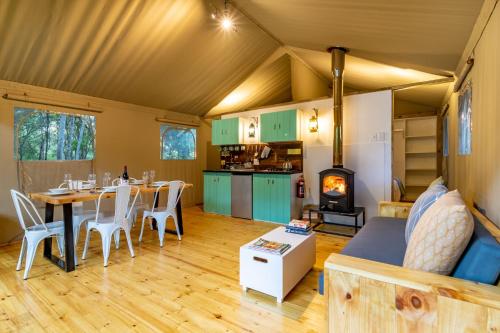 a living room with a dining table and a stove at AfriCamps at Karoo 1 in De Doorns
