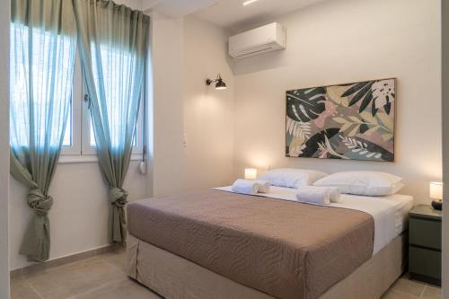 1 dormitorio con 1 cama grande y cortinas azules en Pananos Sq. House II, en Heraklion