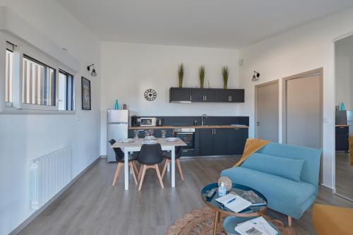un salon avec un canapé bleu et une table dans l'établissement La Petite Maison Cocooning - De plain pied, à Mésanger
