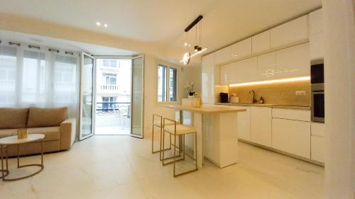 une cuisine et un salon avec un canapé et une table dans l'établissement Le Palais Des Iles, à Cannes