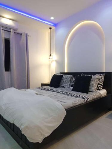 a bedroom with a large bed with a blue light at Entré Quartier Jack in Cotonou