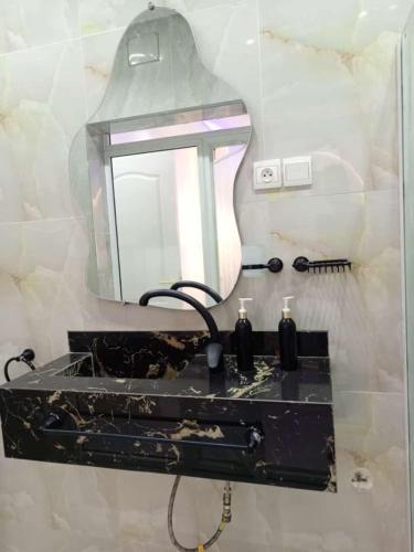 a bathroom with a black sink and a mirror at Entré Quartier Jack in Cotonou