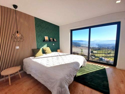 ein Schlafzimmer mit einem großen Bett und einem großen Fenster in der Unterkunft Villa Paoryna in Vila Verde